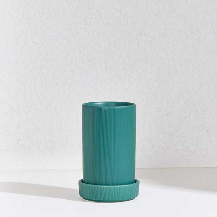 Green ceramic utensil holder with ribbed texture and detachable draining base.
