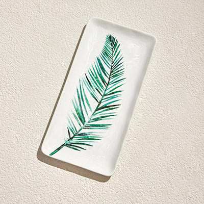 RAINFOREST PORCELAIN PLATE - LA delicate porcelain plate with a smooth, glossy surface. The plate features a minimalist design, with a vibrant green leaf positioned in the center. The leaf is finPorcelain Plate