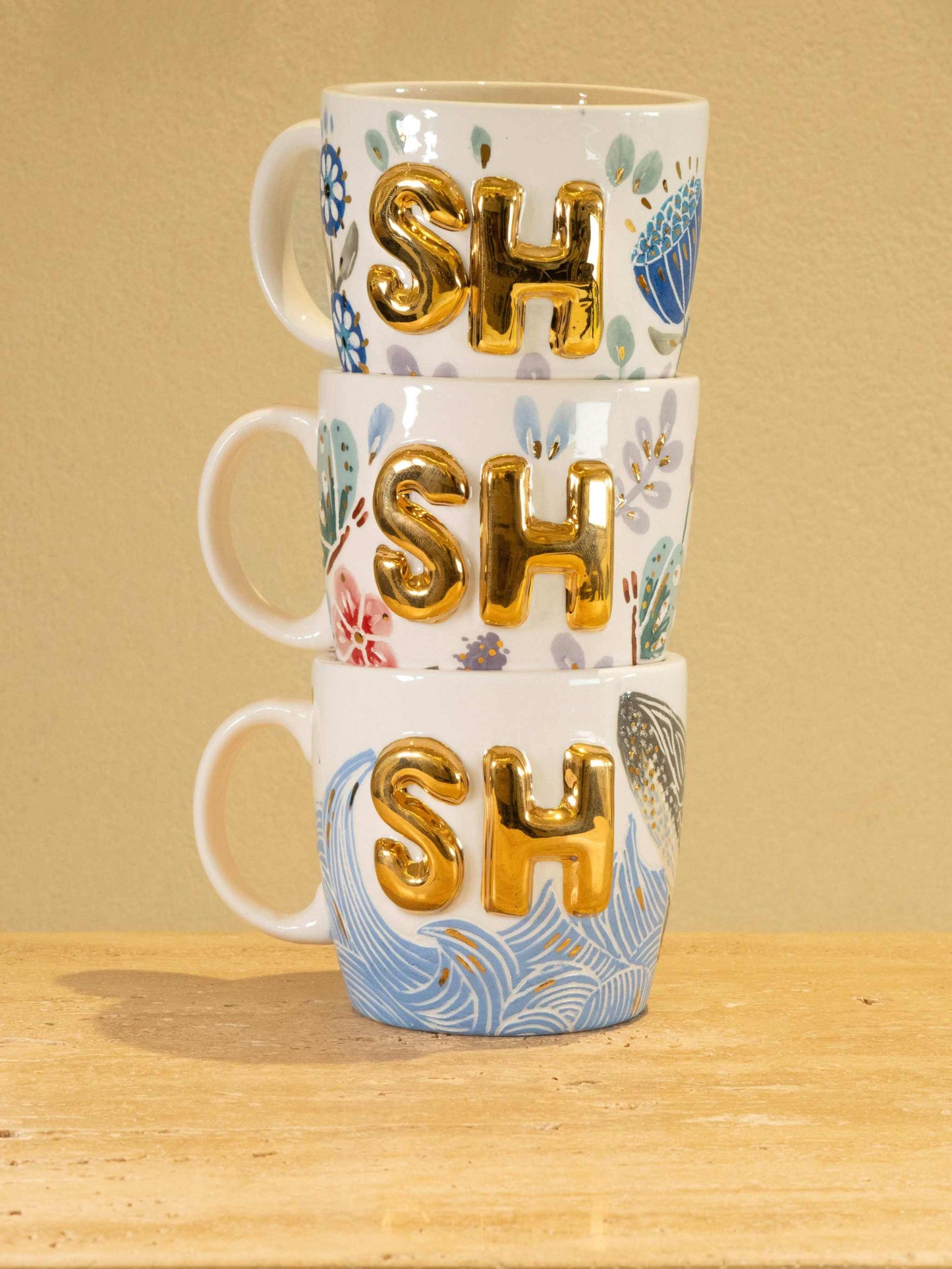 Personalized handmade ceramic mug with gold-plated letters "SH" and floral design.