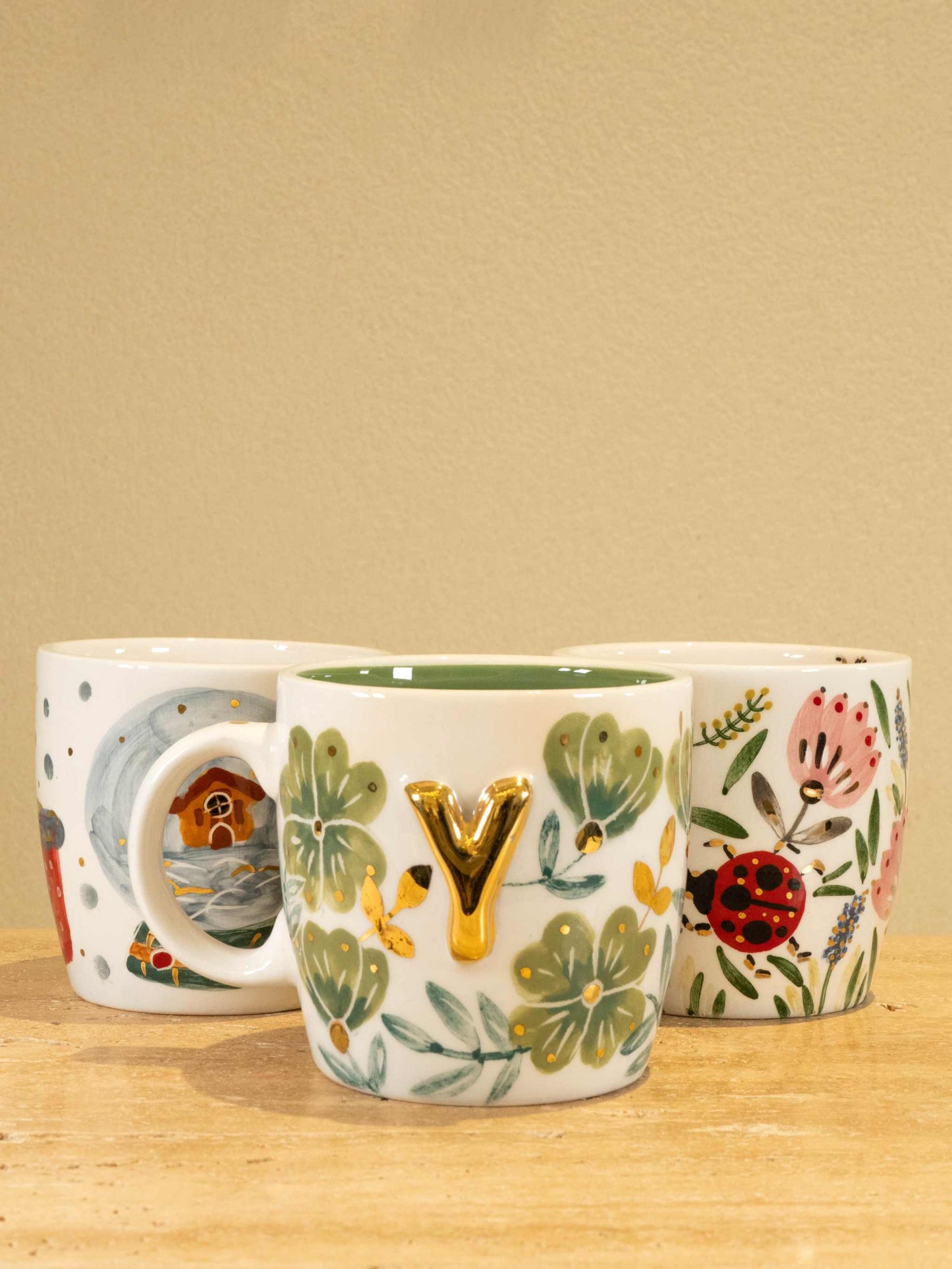 Handmade ceramic mug with gold-plated letter "Y" and floral design.