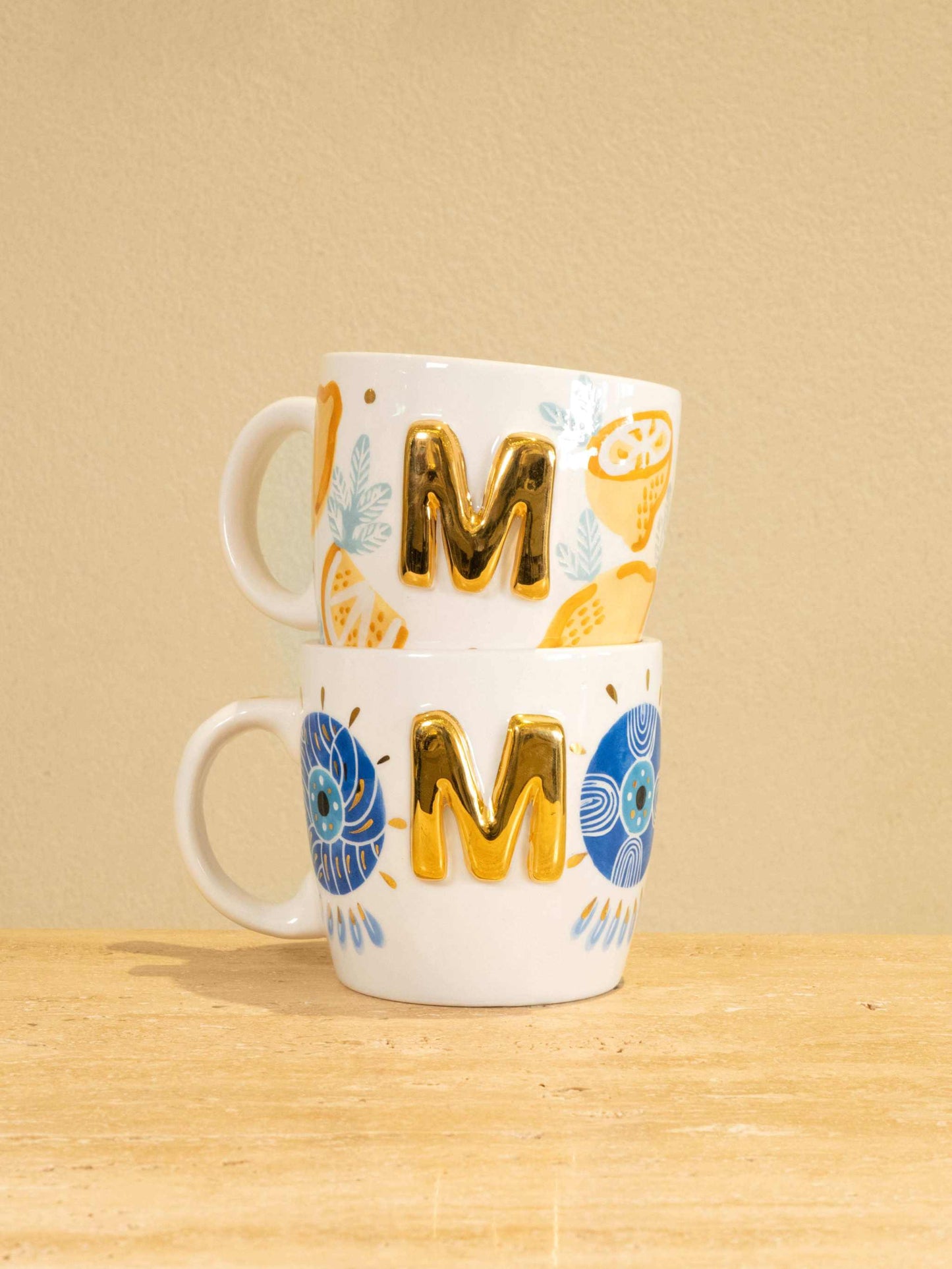 Personalized handmade ceramic mug with gold-plated letter "M" and unique floral design.