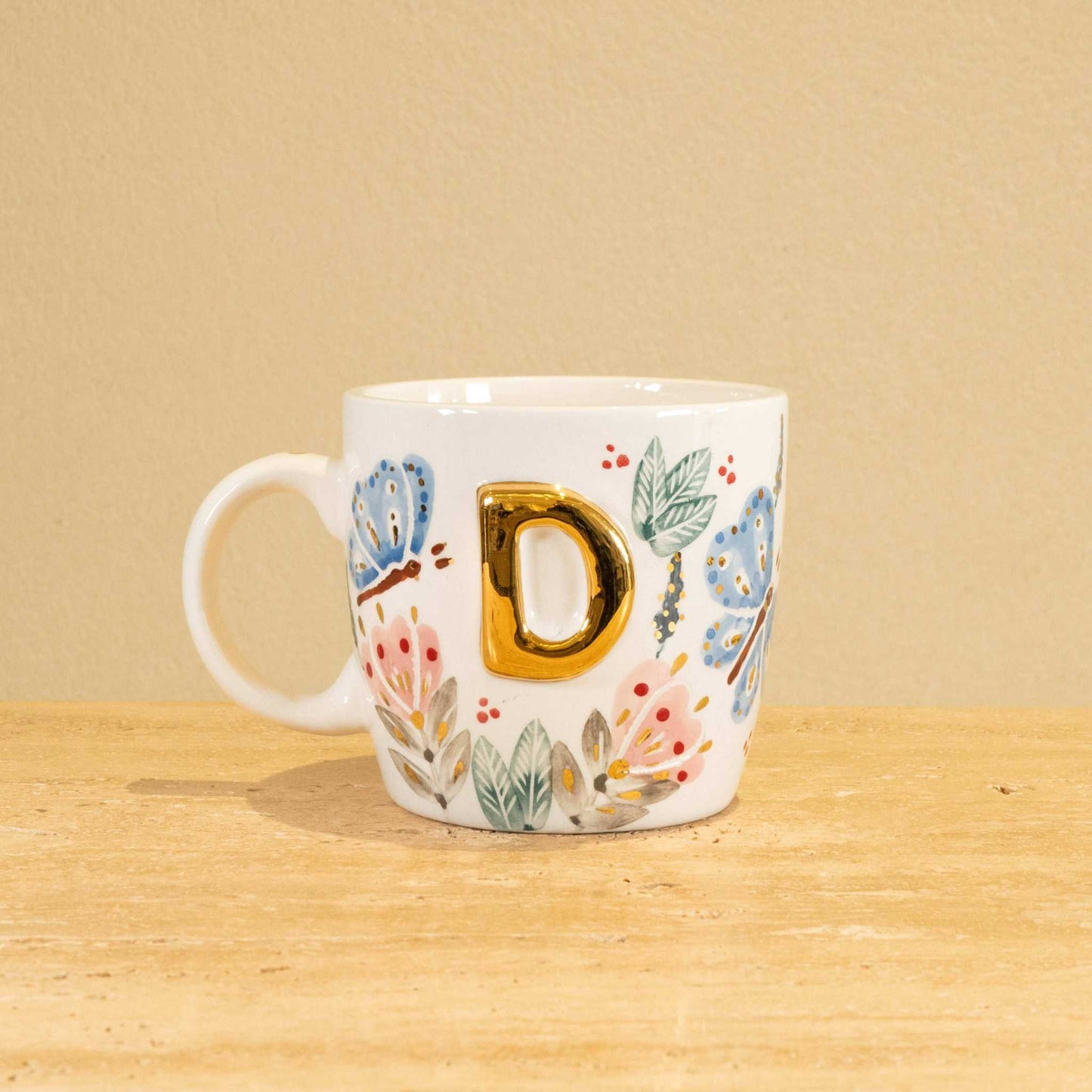Personalized handmade ceramic mug with gold-plated letter "D" and floral design.