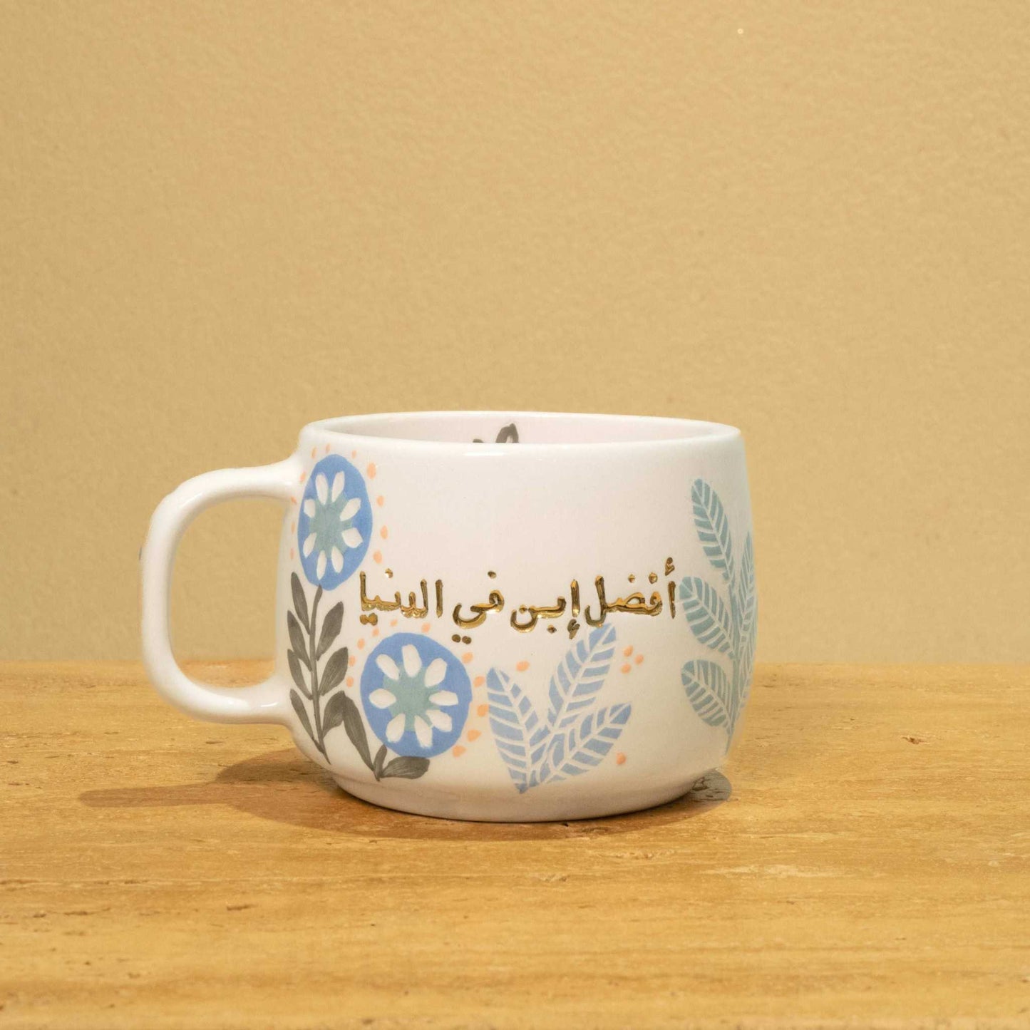 Personalized ceramic mug with gold "Best Son in the World" monogram and floral design.
