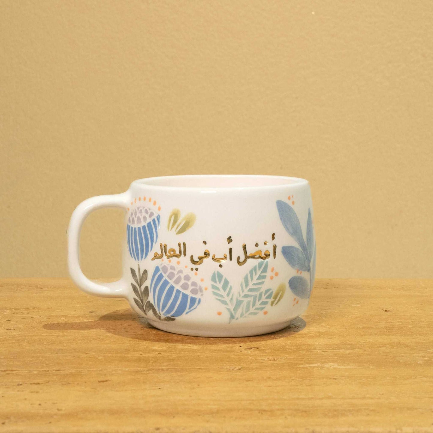 Personalized gold Arabic monogram ceramic mug with floral design, "Best Dad in the World" theme.