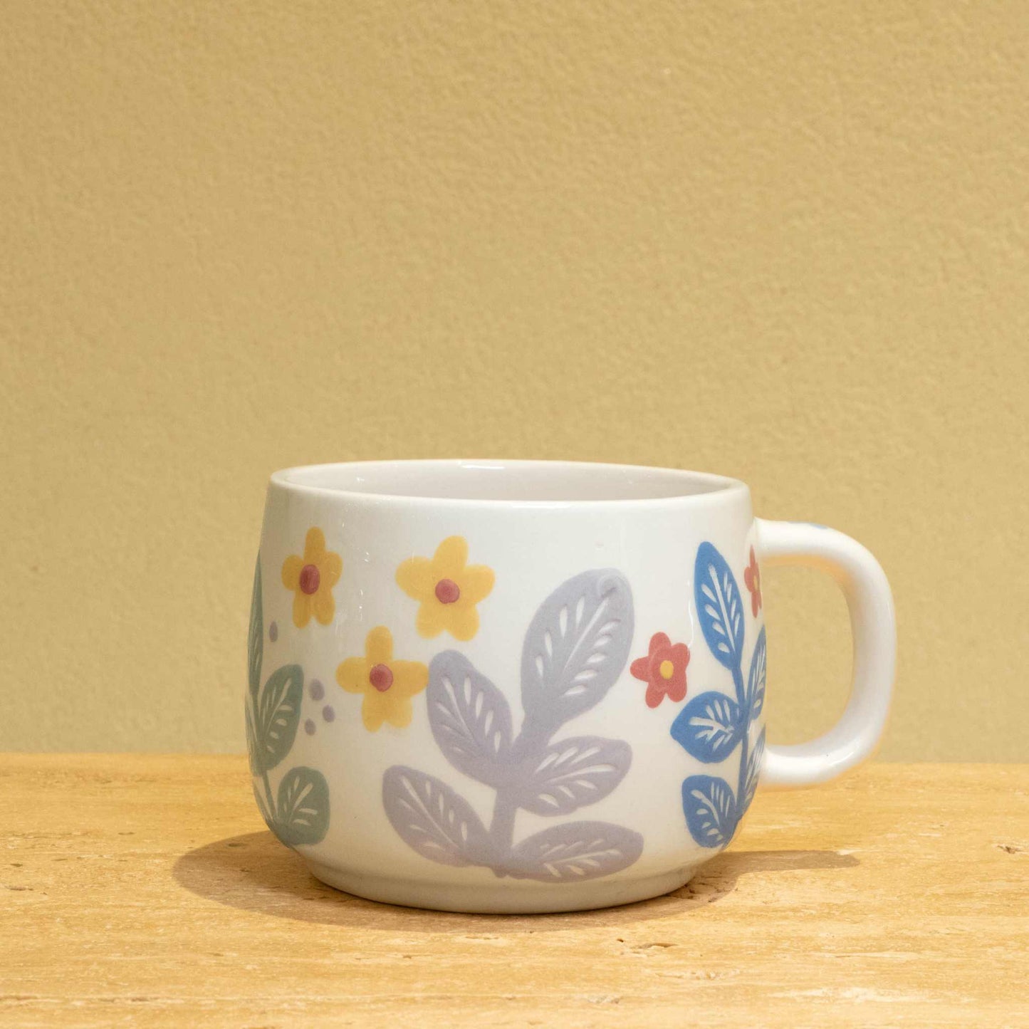 Personalized gold monogram ceramic mug with floral design.