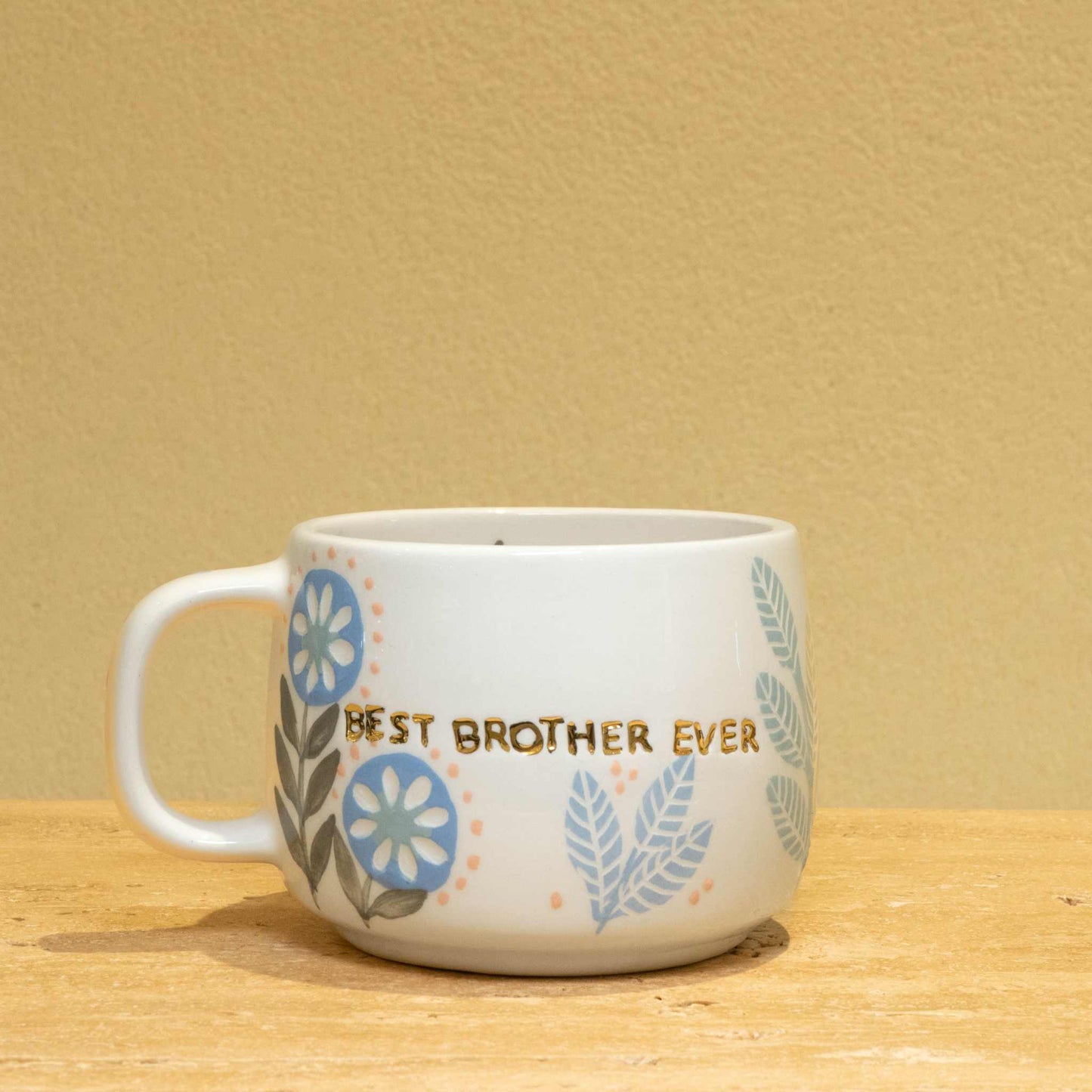 Personalized gold monogram ceramic mug with floral design and "Best Brother Ever" text.