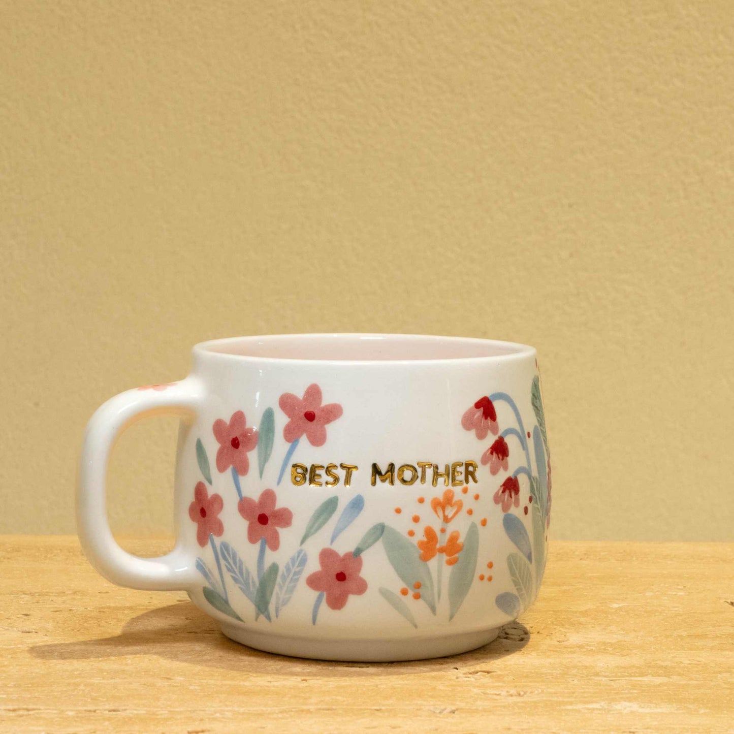 Personalized ceramic mug with gold "Best Mother" and floral design.