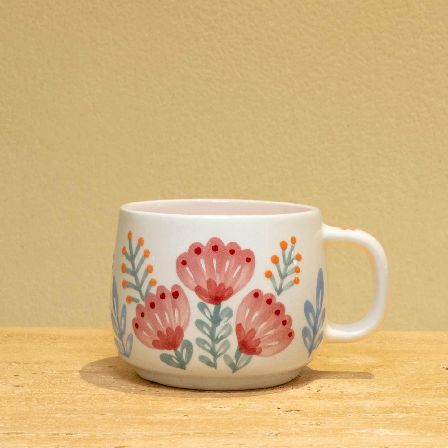 Personalized ceramic mug with gold "BEST MOTHER" monogram and floral design.