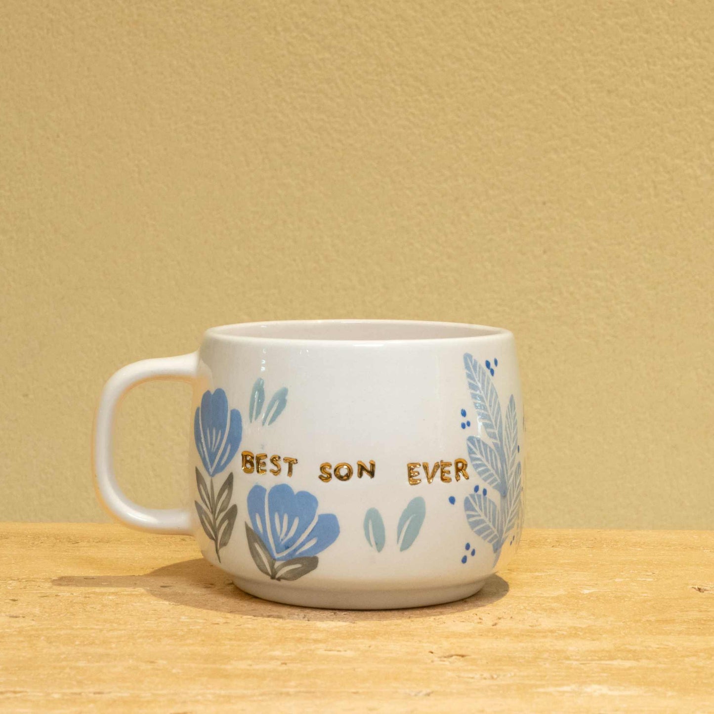 Personalized ceramic mug with gold "Best Son Ever" text and floral design.