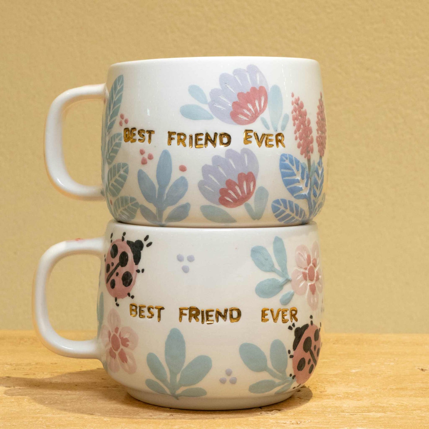 Handmade ceramic mug with "Best Friend Ever" in gold and floral design.