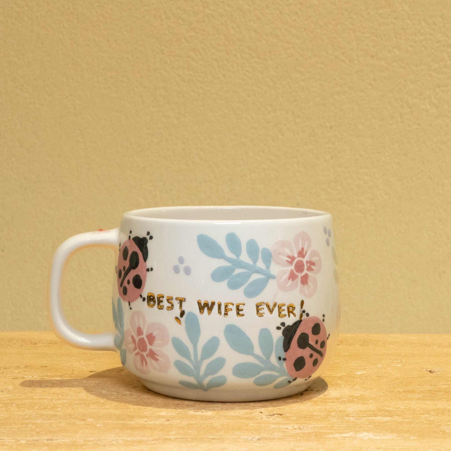 Personalized gold monogram ceramic mug with "Best Wife Ever" floral design.