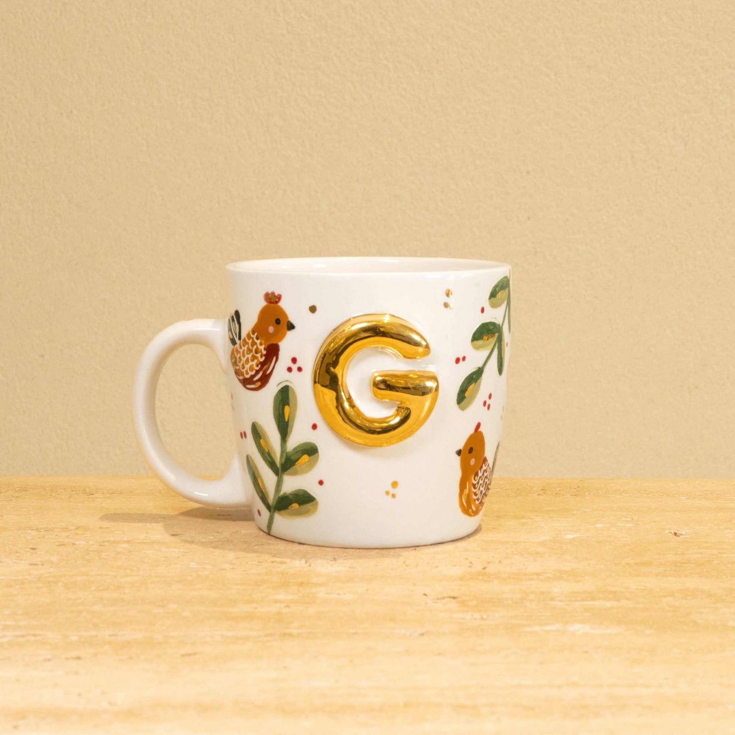 Custom handmade ceramic mug with gold-plated initial "G" and floral design.