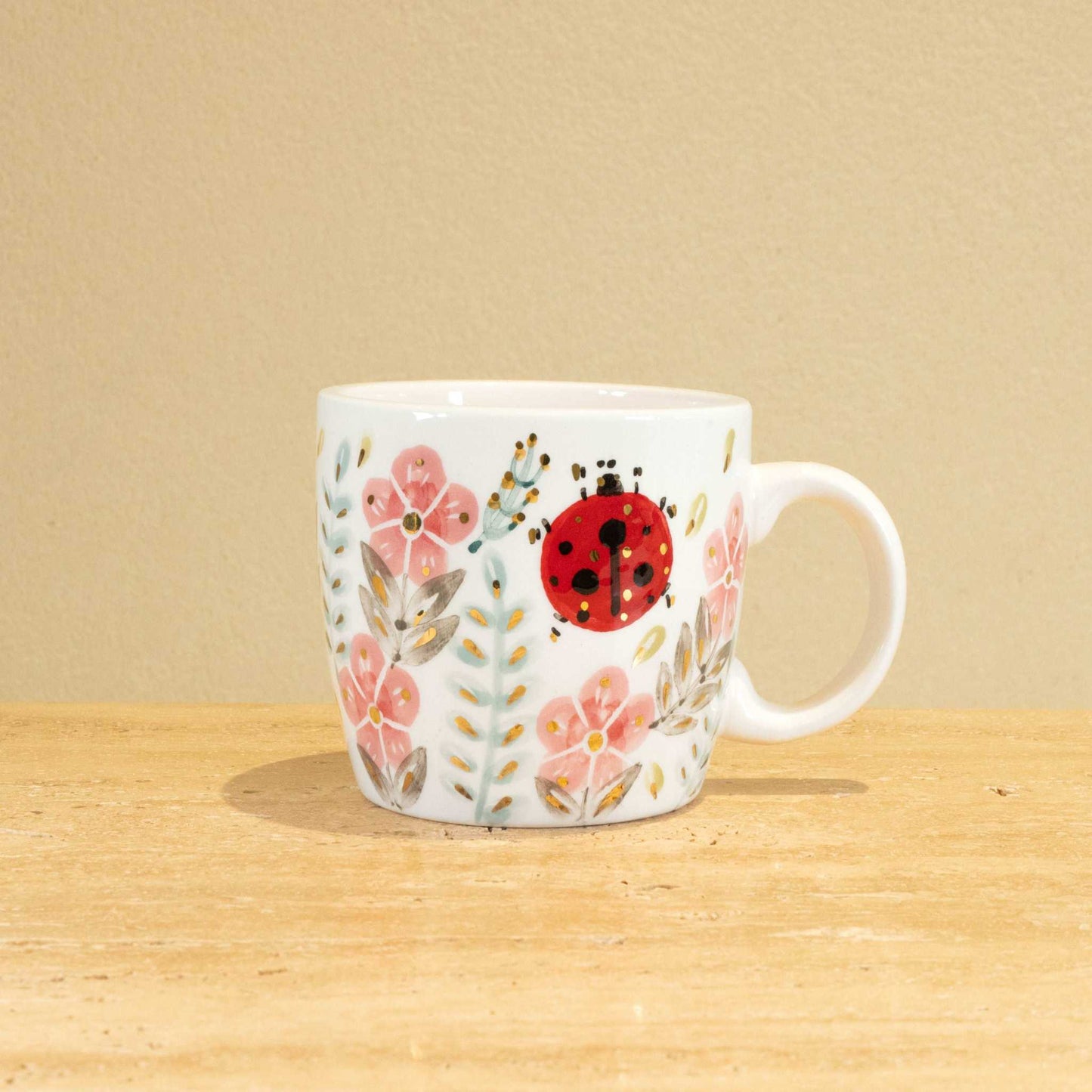 Custom handmade ceramic mug with gold-plated initial "K" and unique floral design.