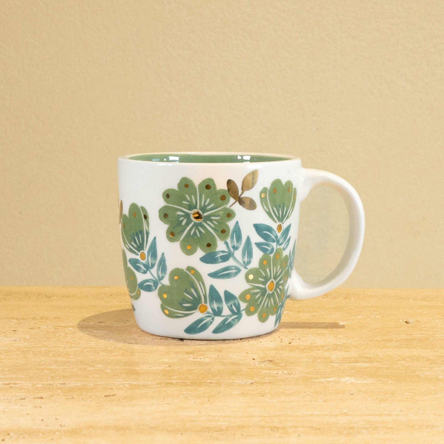 Custom handmade ceramic mug with gold-plated "L" and floral design.