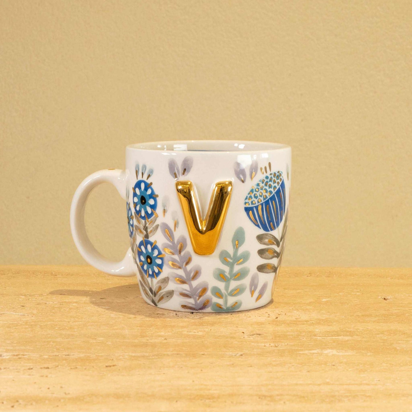 Custom handmade ceramic mug with gold-plated initial "V" and floral design.
