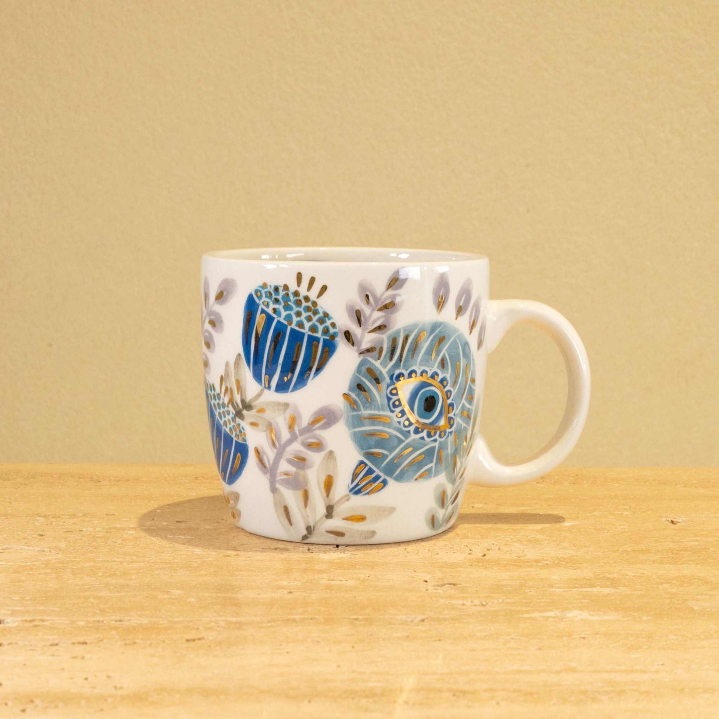 Handmade ceramic mug with gold-plated initial V and intricate floral design.