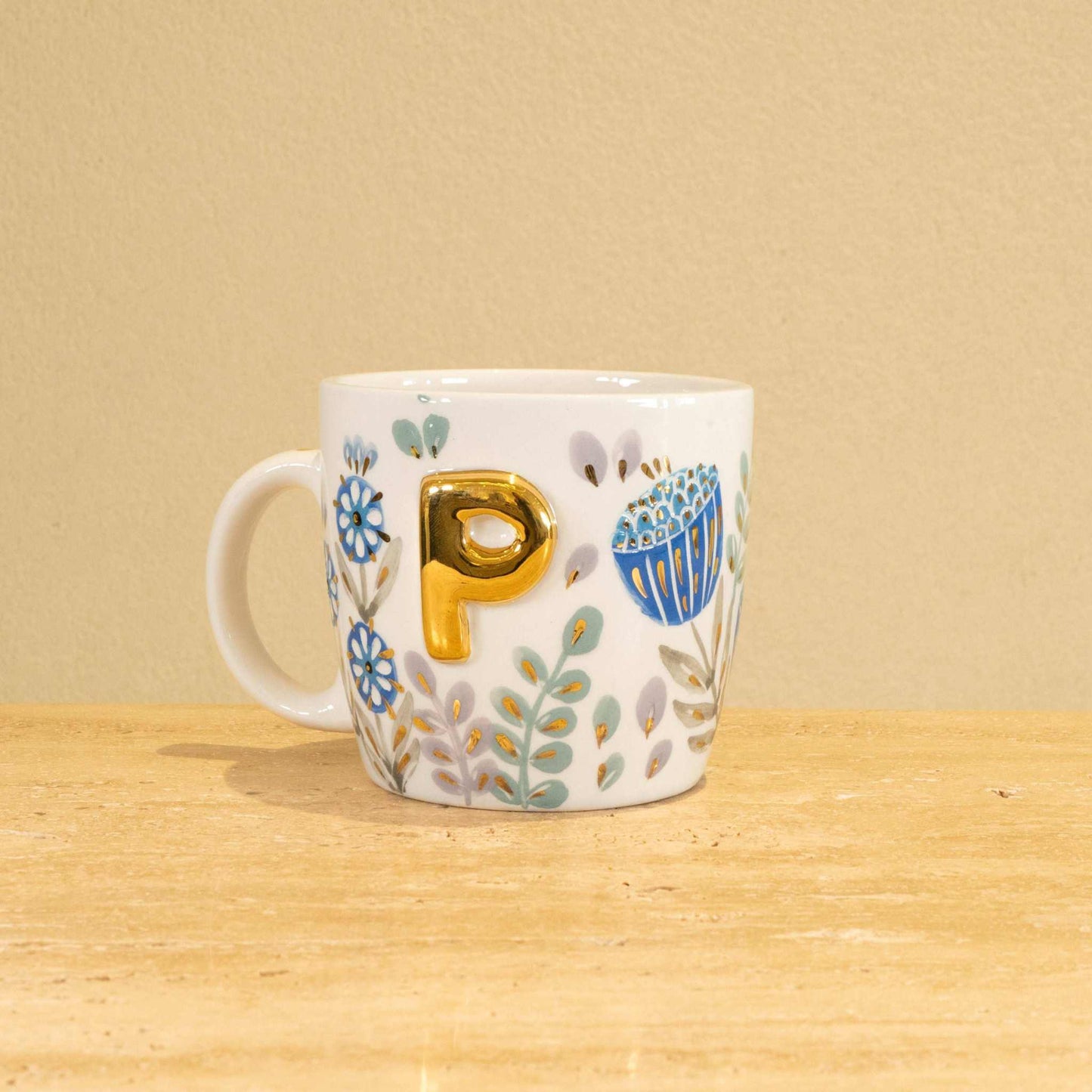 Custom handmade ceramic mug with gold-plated initial "P" and floral design.