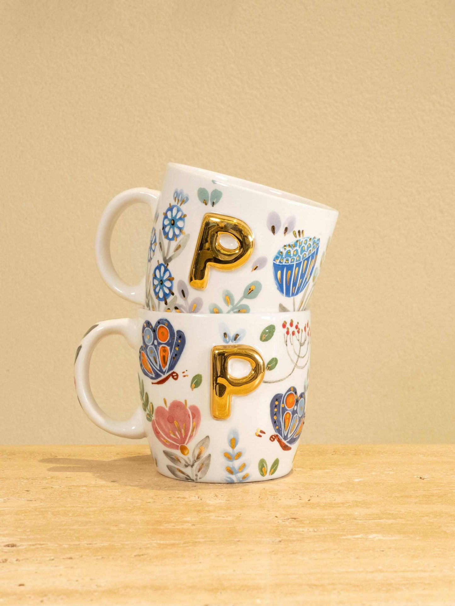 Custom handmade ceramic mug with gold-plated initial "P" and floral design.