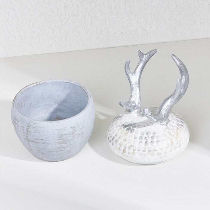 Silver deer horn decoration with a weathered base and antler lid.