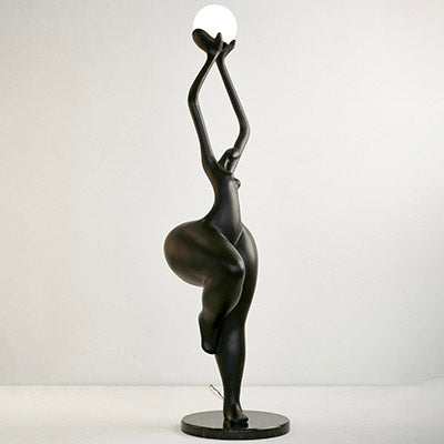 Dream Dancer Sculptural Floor Lamp in matte black with abstract human form holding a luminous globe, set on a metal base.
