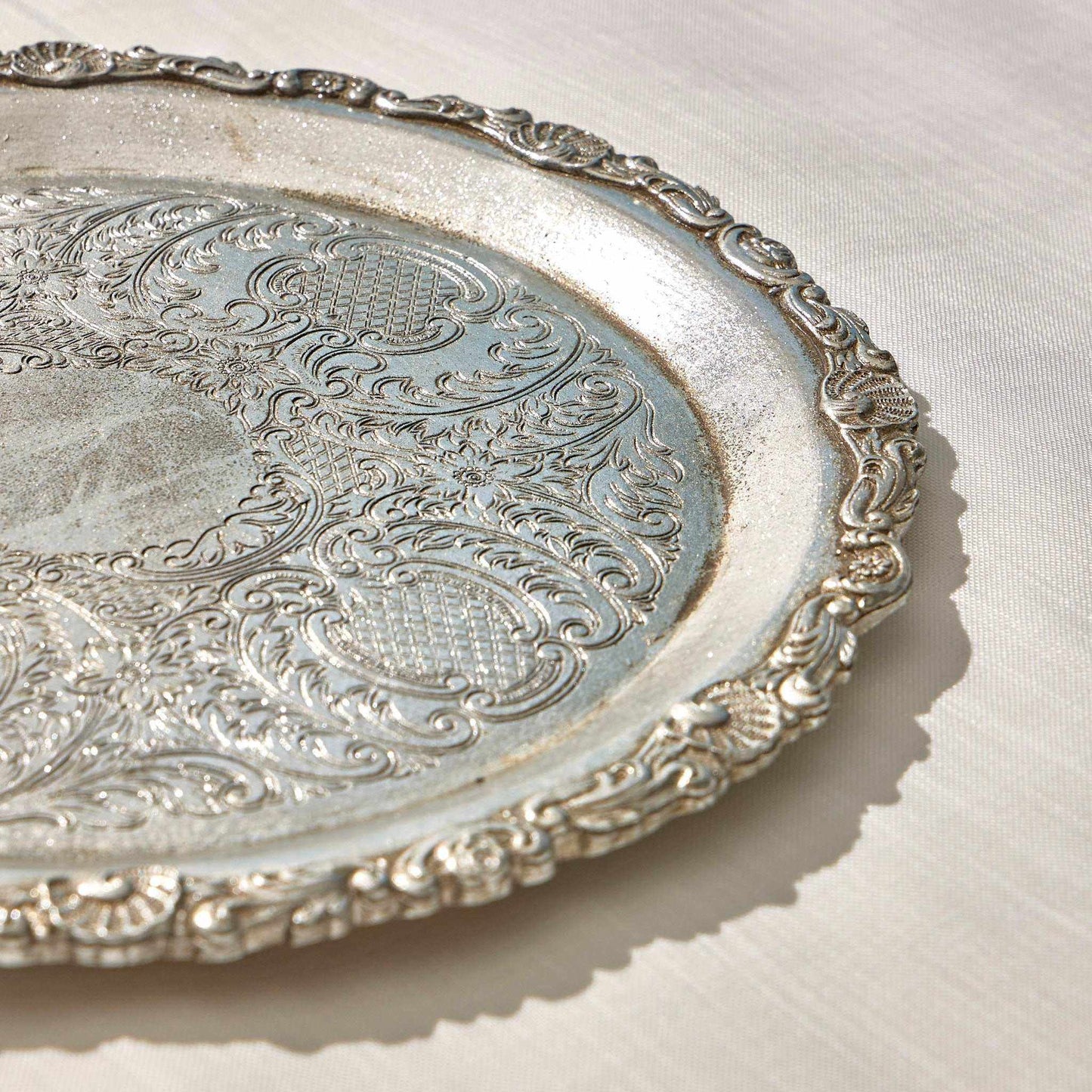 Sleek minimalist serving round tray with polished surface and black curved edges.