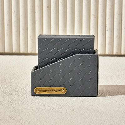 Gray Leather Coaster Set with woven texture and brass label, ideal for modern homes or offices.