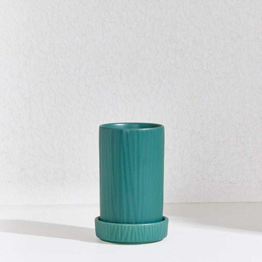 Green ceramic utensil holder with ribbed texture and detachable draining base.