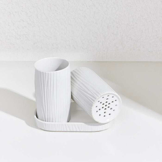Grey ceramic utensil holder with a ribbed texture and detachable draining base.