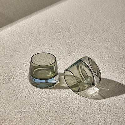 JOY GLASS T-SET of 2 in light gray on textured surface, highlighting elegant glassware.