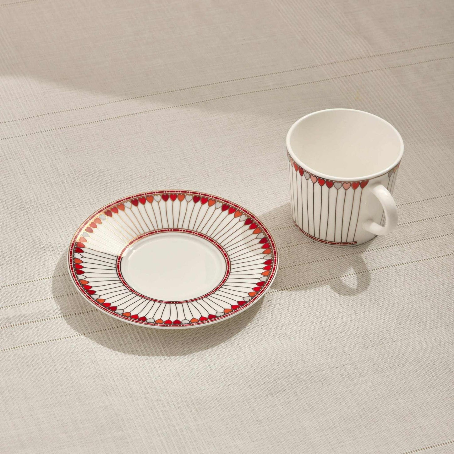HEARTS PORCELAIN TEA CUP - REDAdd a touch of elegance to your tea time with this beautifully crafted porcelain tea cup and saucer set. Featuring a captivating red and white design with delicate hCUP AND SAUCER