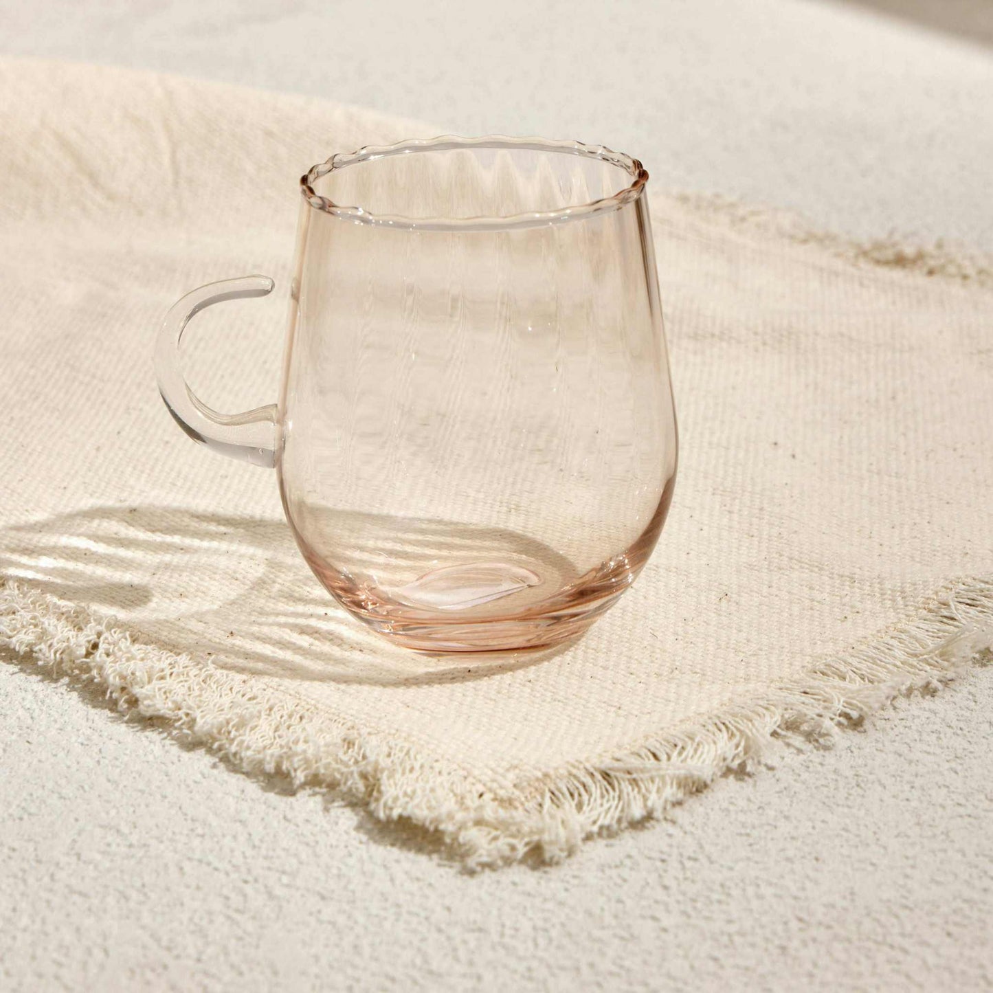 OPTIC CUP TARCINEIndulge in timeless elegance with the Optic Cup Tarcine, a beautifully crafted rippled glass mug designed for sophistication and style. With a delicate amber tint anGlass Mug