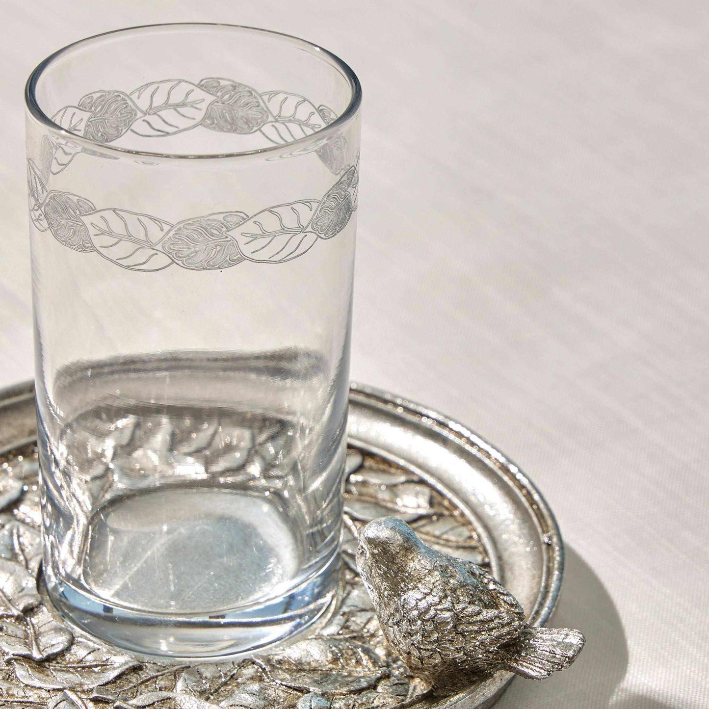 SPARROW - WATER SET SILVERBring elegance to your table with the "Sparrow" Water Set in a timeless silver finish. This exquisite set features a delicately engraved glass and an intricately desCUP AND SAUCER
