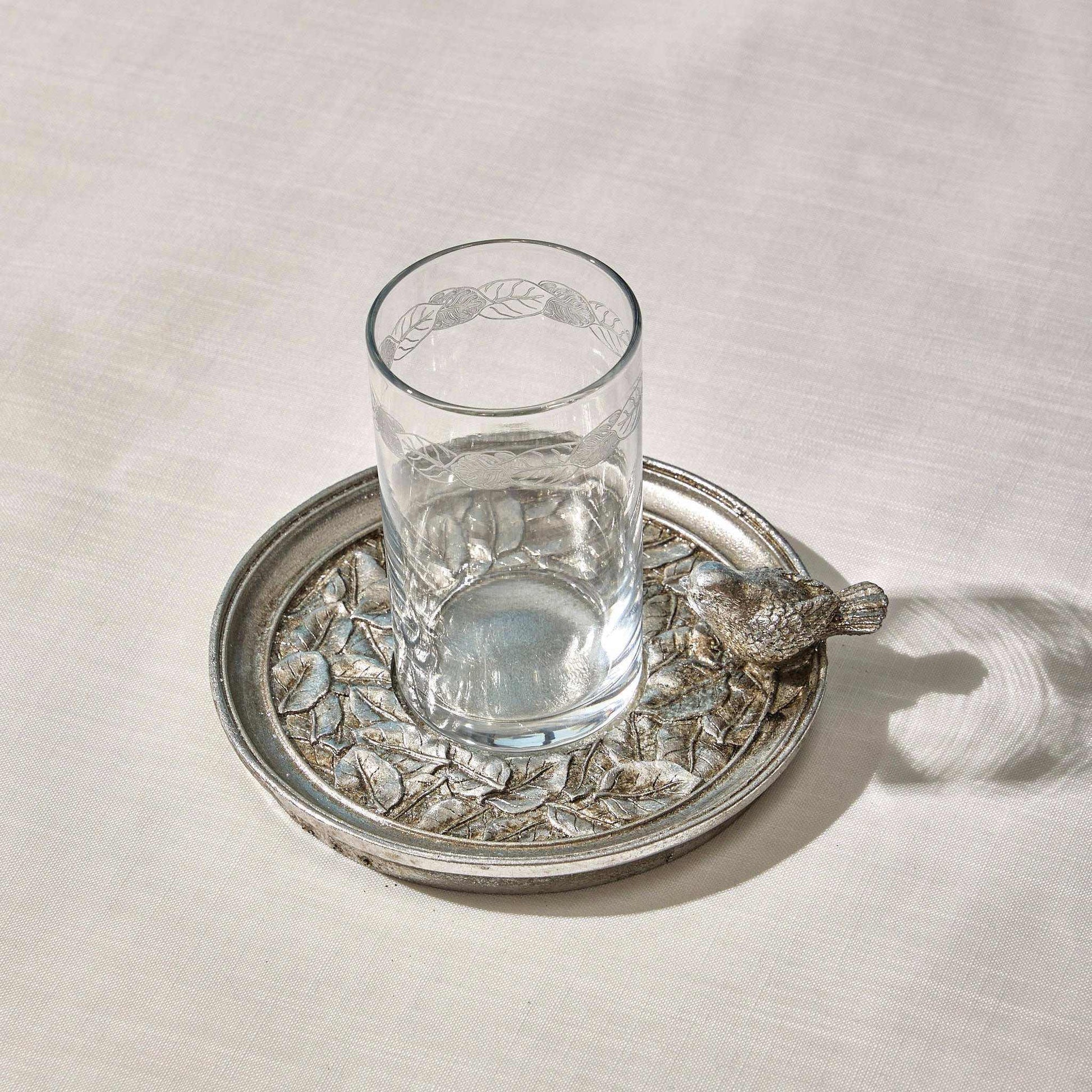 Silver water set with engraved glass and intricately designed plate featuring a sculpted sparrow accent.