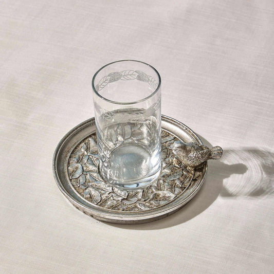 Silver water set with engraved glass and intricately designed plate featuring a sculpted sparrow accent.