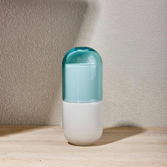 Sky blue water night set with minimalist carafe and matching glass on a bedside table.