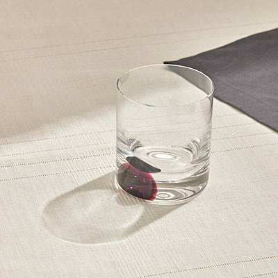 DOT Whiskey Glass - Violet with spinning base on table, designed for whiskey and cocktails.