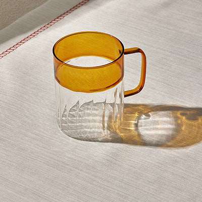 Amber ripples cup with unique textured design on a table surface.
