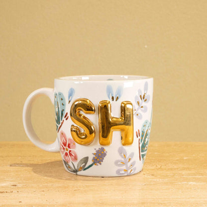 Personalized handmade ceramic mug with gold-plated 'SH' and floral design.