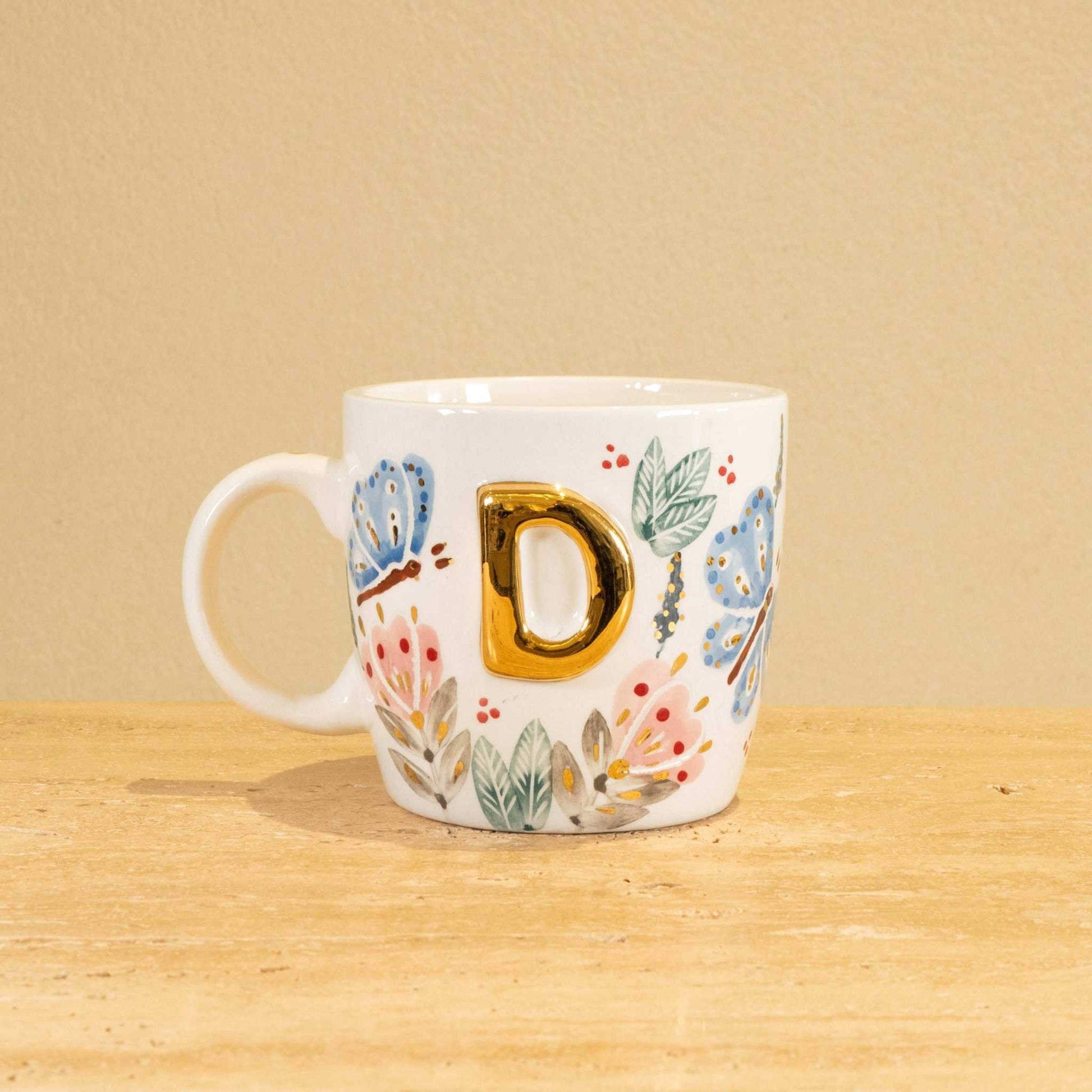 Personalized handmade ceramic mug with gold-plated letter "D" and floral design.