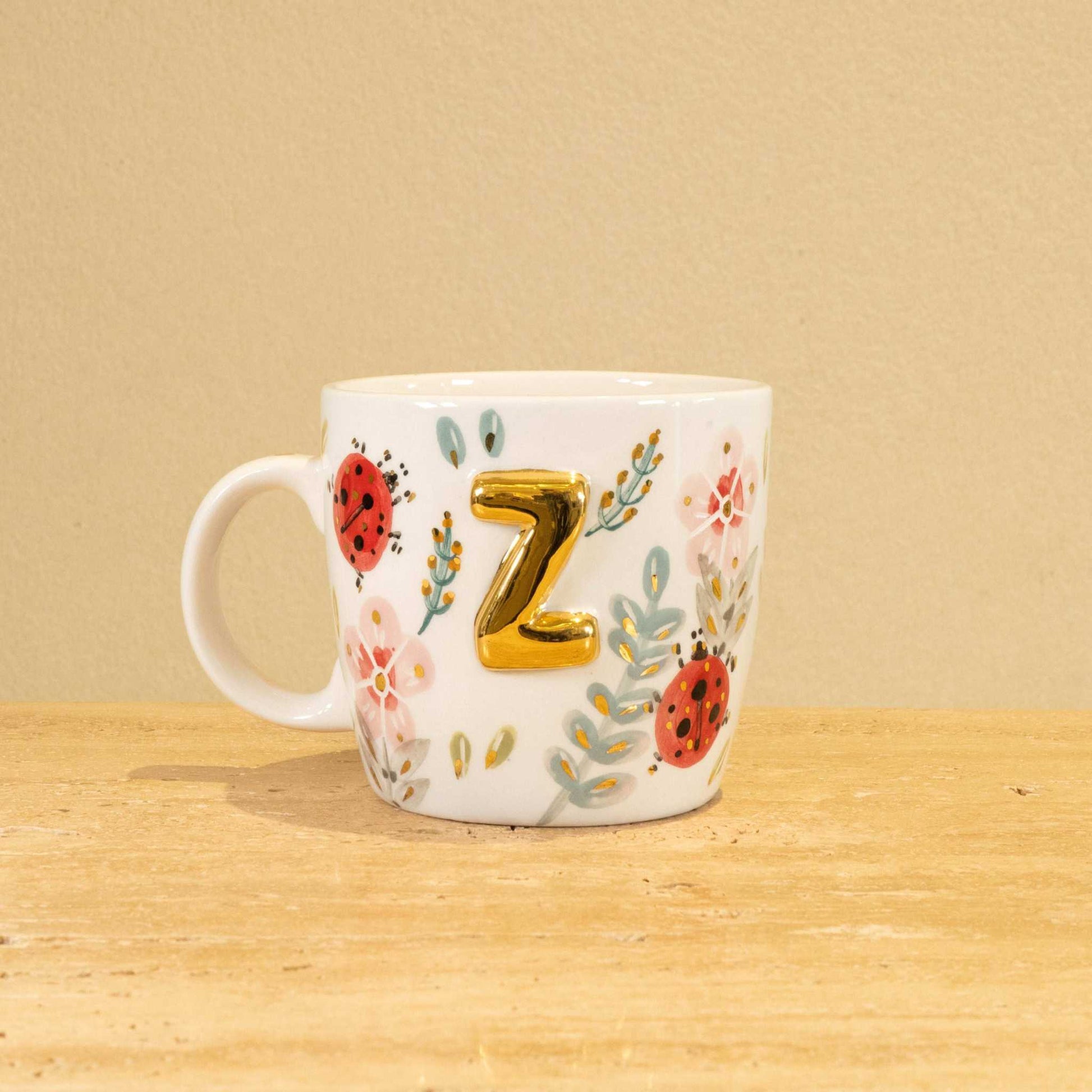 Custom handmade ceramic mug with gold-plated "Z" and floral design.