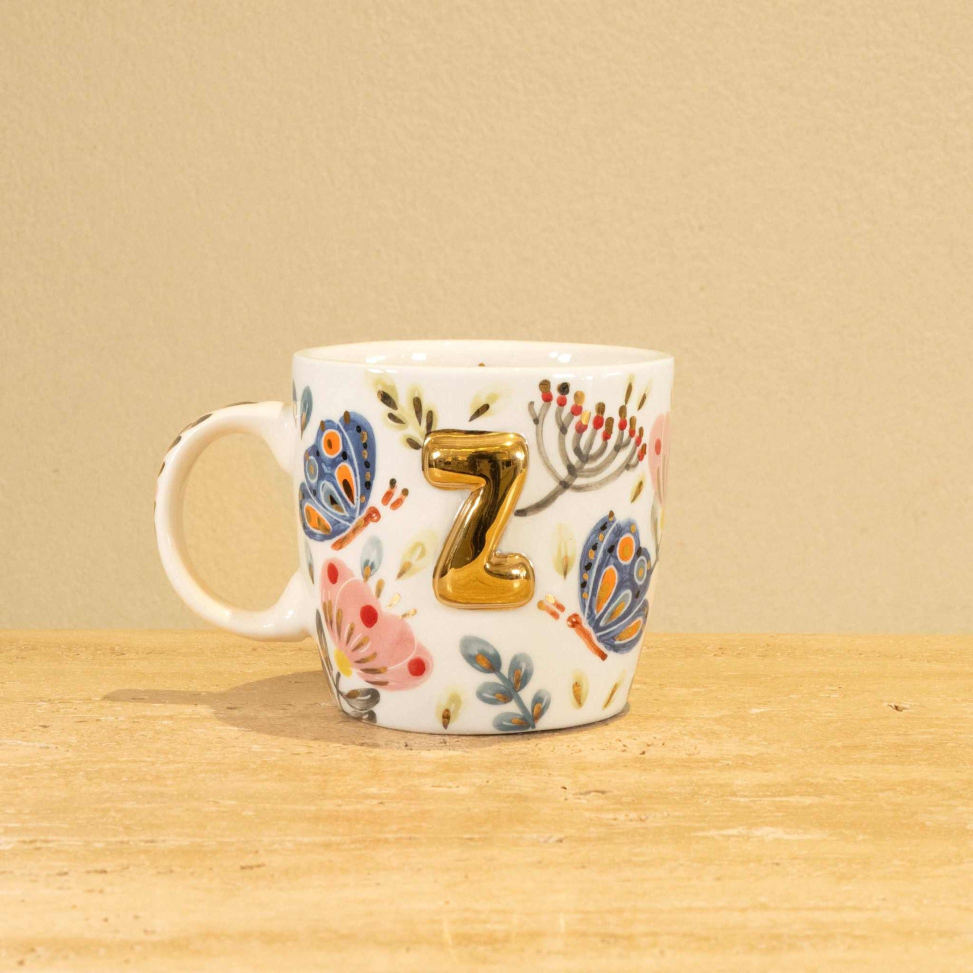 Custom handmade ceramic mug with gold-plated initial "Z" and floral design.