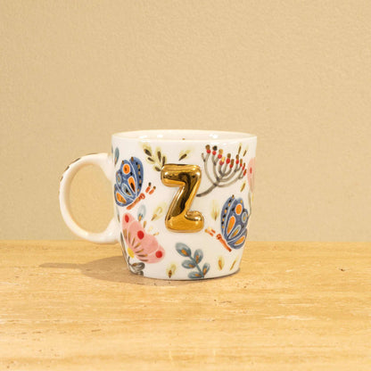 Custom handmade ceramic mug with gold-plated initial "Z" and floral design.