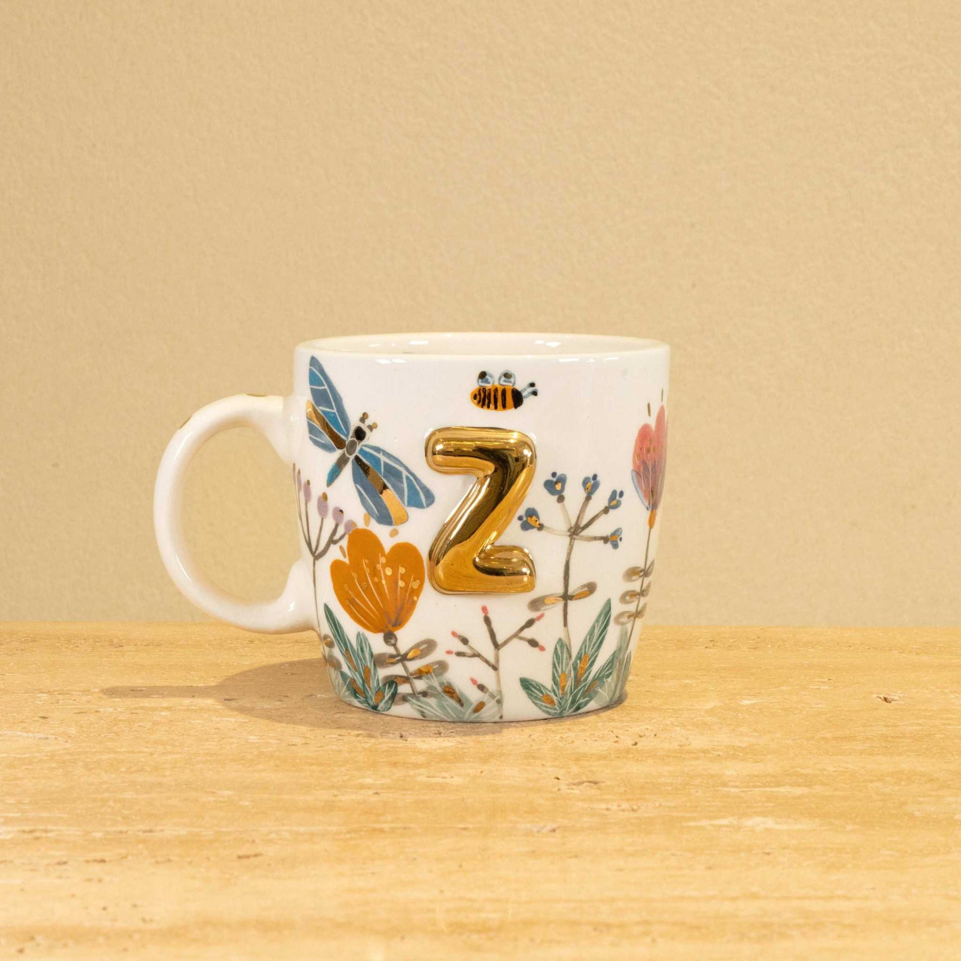 Custom handmade ceramic mug with gold-plated initial "Z" and floral design.