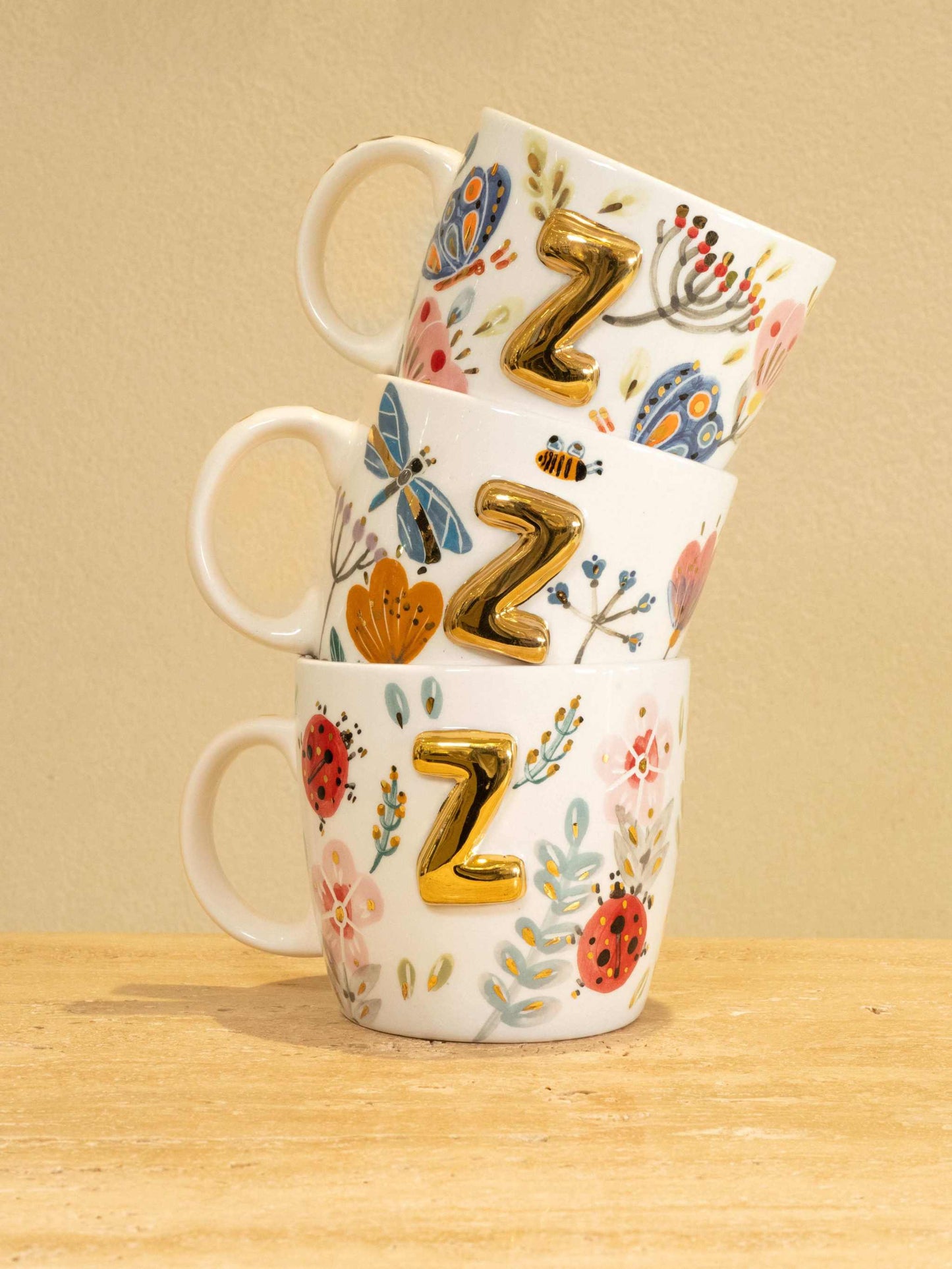 Custom handmade ceramic mug with gold-plated initial "Z" and floral design.