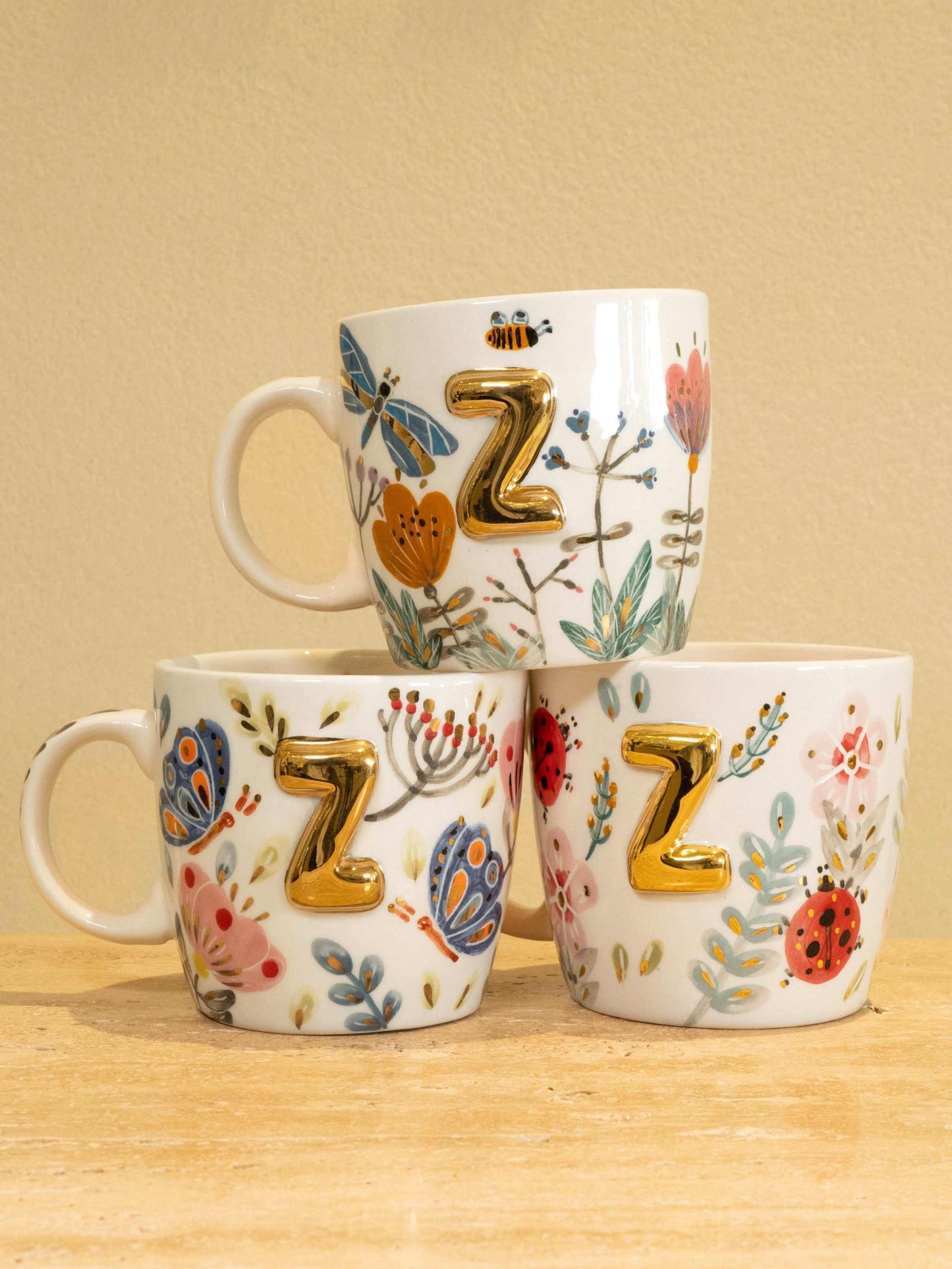 Custom handmade ceramic mug with gold-plated initial "Z" and floral design.