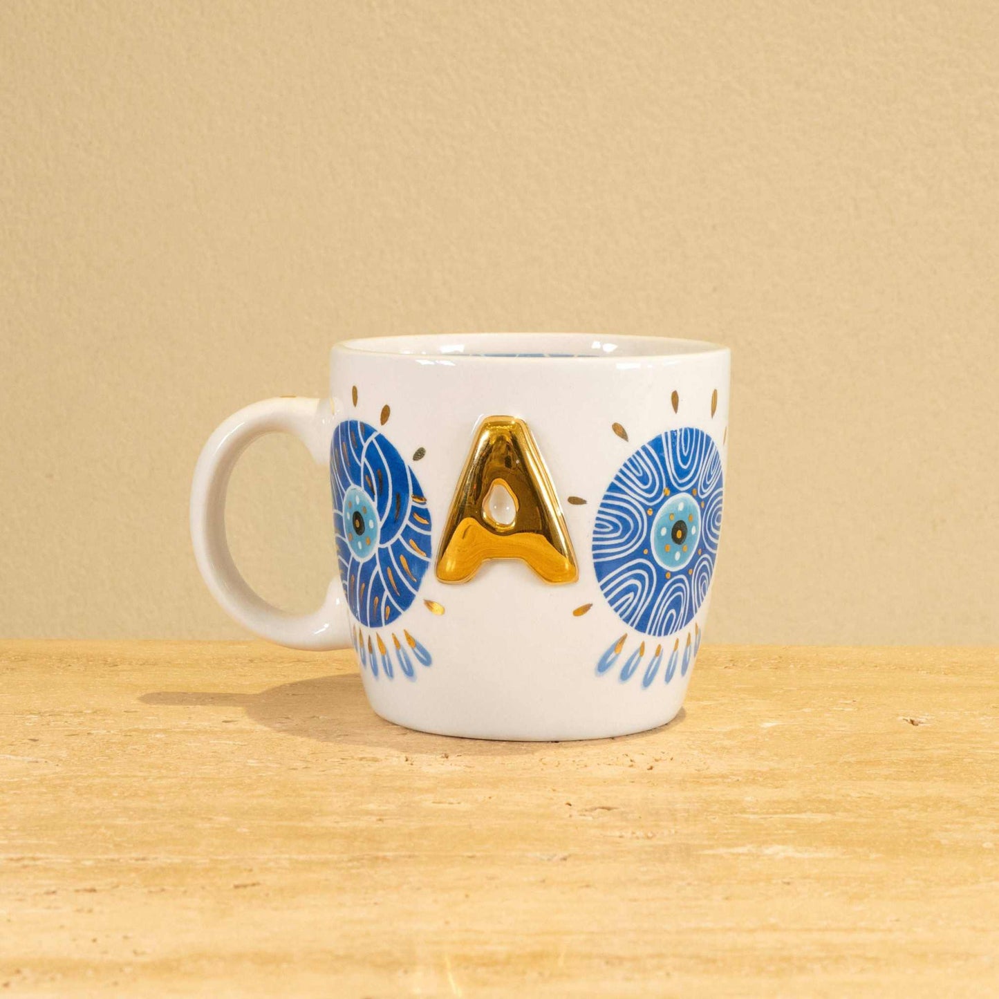 Custom handmade ceramic mug with gold-plated initial "A" and floral design.