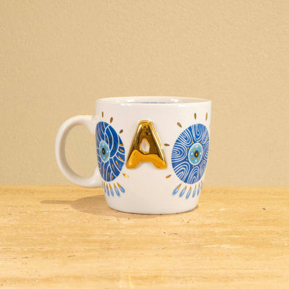 Custom handmade ceramic mug with gold-plated initial "A" and floral design.