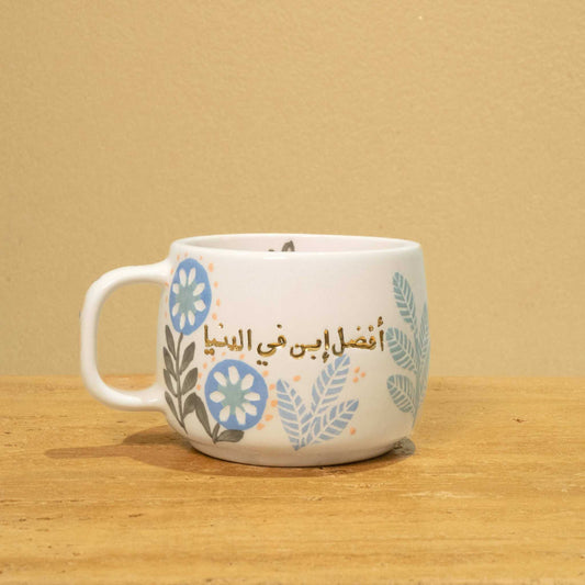 Personalized ceramic mug with gold "Best Son in the World" monogram and floral design.