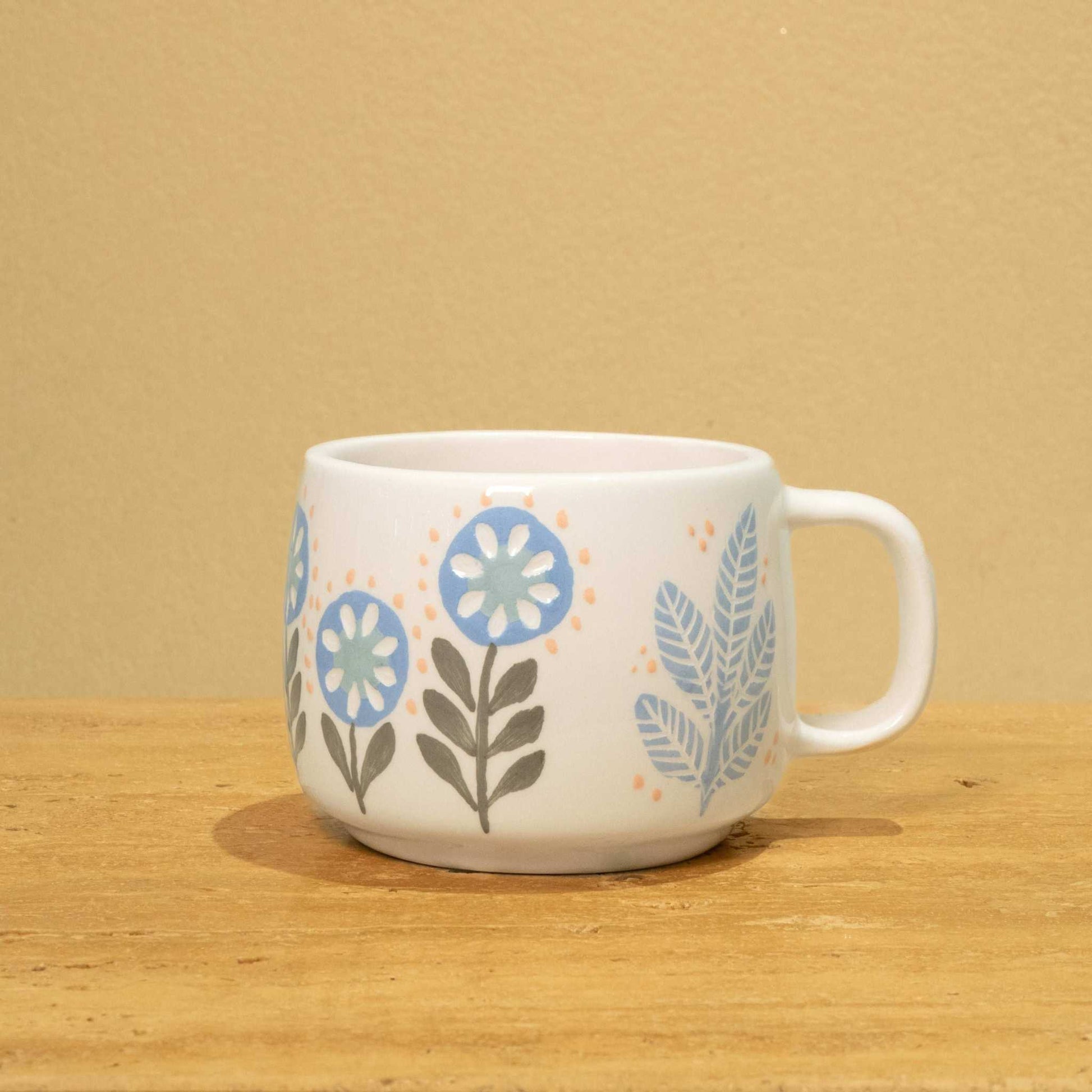 Personalized ceramic mug with gold Arabic monogram "Best Son in the World" and floral design.