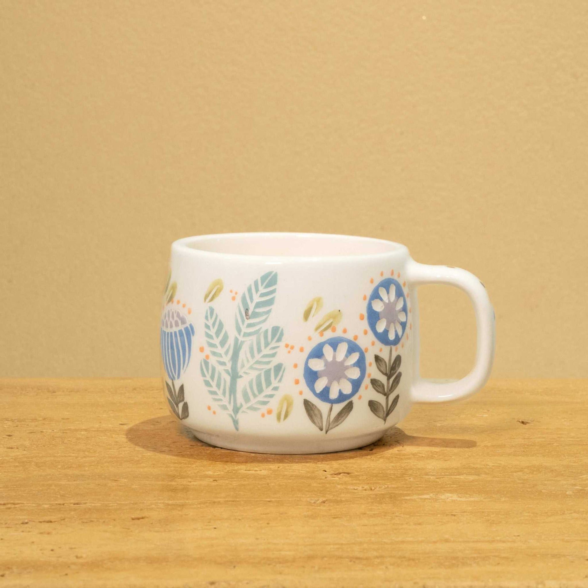 Handmade ceramic mug with gold Arabic monogram "Best Dad in the World" and floral design.